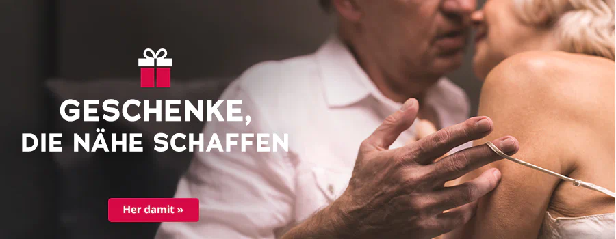 Das Bild zeigt eine Werbeanzeige, wo eine Frau und ein Mann dicht aneinander stehen. Der Mann trägt ein weisses Hemd und die Frau ein helles Oberteil mit dünnen Trägern. Die Köpfe sind dicht beieinander und der Mann macht mit seiner Hand den dünnen Träger der Frau an ihrer Schulter runter. Plakativ steht in grosser, weisser Schrift "Geschenke, die Nähe schaffen“. Symbolisch ist ein Geschenk abgebildet. Unterhalb befindet sich ein rotfarbener Button mit der weissen Aufschrift „Her damit“.