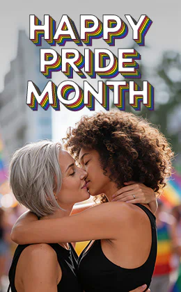 Zwei Frauen küssen sich eng umschlungen vor einer unscharfen Pride-Umgebung. Eine hat silbernes, kurzes Haar, die andere lockiges braunes Haar. Links steht „HAPPY PRIDE MONTH“.