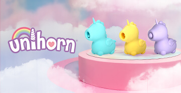 Drei bunte Sextoys in Einhornform in Türkis, Gelb und Lila auf einem rosa Podest vor einem Hintergrund mit Wolken und Regenbogen. Links der verspielte Schriftzug 'unihorn' mit Herz und Horn.